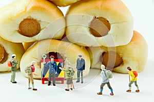 Tiny toys businessman and Sausage bread.Concept food background.