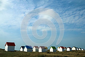 The tiny white beach cottages with colorful roofs