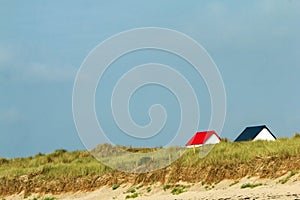 The tiny white beach cottages with colorful roofs