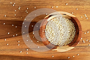 Tiny white sesame seeds in small wooden bowl, view from above