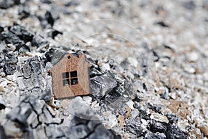 Tiny wooden house on an  ash . Fire concept