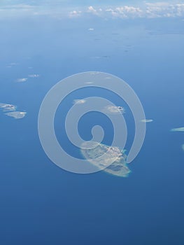 Tinyy archipelago islands in the middle of ocean, pictured from jetplane photo