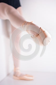 Tip of a ballet shoe for ballet dancing with a dancer posing with a raised leg