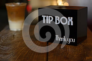 Tip box in coffee shop with low light blurred