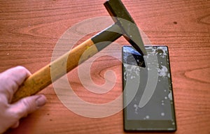 The tip of the hammer hit the screen of the smartphone