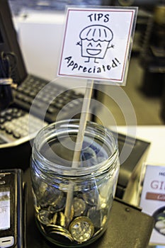 Tip Jar with coins on restaurant counter