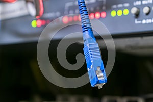 The tip of the optical cable is on a technological background. Fiber optic patch cord is close up.  Concept of high speed internet