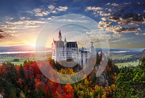 Tipical postcard. Majestic Neuschwanstein castle during sunset, with colorful clouds under sunlight. Dramatik Picturesque scene.