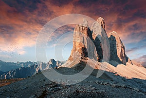 Tipical postcard. Majestic Tre peaks di Lavaredo during sunset, with colorful clouds under sunlight. Dramatic Picturesque scene.