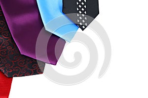 Tips of colorful neckties with elegant patterns on the edge of a white background with copy space