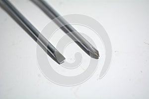 The tips of flathead screwdriver and Phillips head screwdriver