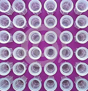 tips for laboratory pipettes. Arranged symmetrically. Bordeaux background.
