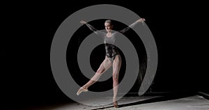 Tips on toes. graceful ballerina dancing alone isolated on black isolated background