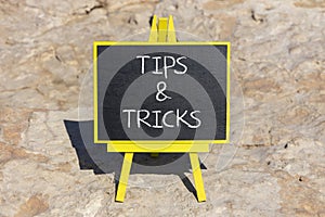 Tips and tricks symbol. Concept words Tips and tricks on black chalk blackboard on a beautiful stone background. Business and tips