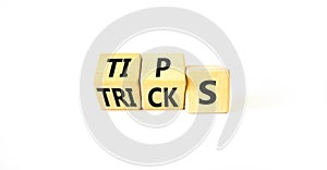 Tips and tricks symbol. Turned wooden cubes and changed the word tricks to tips. Beautiful white table, white background. Business