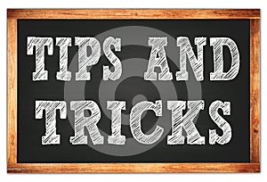 TIPS AND TRICKS words on black wooden frame school blackboard