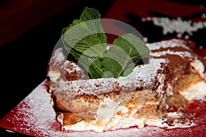 Tiramissu. Sweet chocolate dessert with cream and powdered sugar