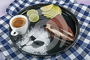 Tiramisu cake and coffee. Stylish Italian dessert with a piece of Tiramisu cake on a black plate and a cup of black coffee, served