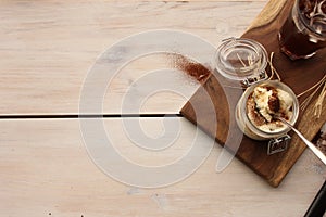 Tiramisu with a cup of iced coffee, top view on wooden board