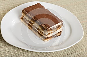 Tiramisu on a plate with a bamboo mat