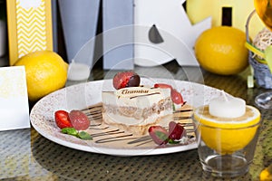 Tiramisu on a plate with strawberries and sauce in still life, chocolate design