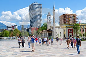 Group of tourists on Skanderbeg square. Efem Bey Mosque, Clock Tower, Plaza Hotel, Tirana, Albania