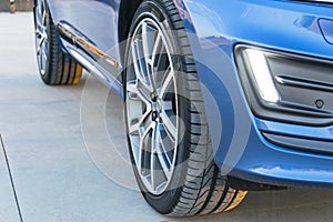 Tire and alloy wheel of a modern car on the ground.