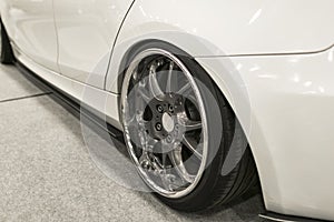 Tire and alloy wheel of a modern white car on the ground. car exterior details