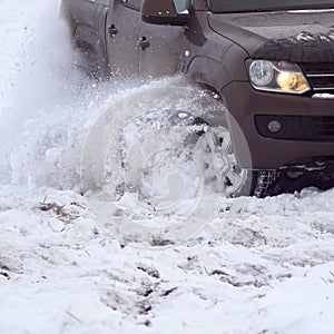 Tire on car wheel close-up skidding on a snowy winter road