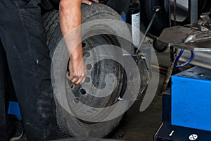 Tire change closeup, Mechanic is changing car tire engineer balancing car wheel on balancer in workshop