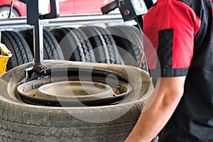 Tire change closeup, Mechanic is changing car tire engineer balancing car wheel on balancer in workshop