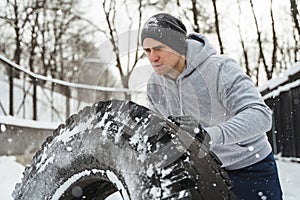Strong sportsman during his cross training workout during snowy and cold winter day.