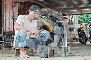 Tire patcher sitting scrubbing a leaky inner tube