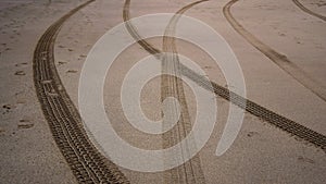 Tire prints on beach sand left by off-road vehicle