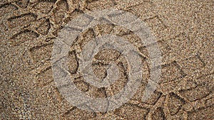 Tire prints on beach sand left by off-road vehicle