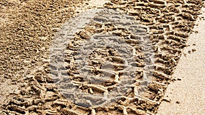 Tire prints on beach sand left by off-road vehicle