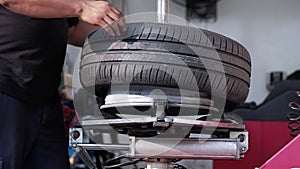 Tire Replacement concept. Mechanic Working his Job with Wheel in Garage. Car Maintenance and services.Slow Motion