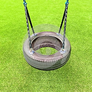 Tire swing on green grass background