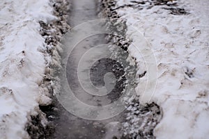 Tire track in the melting snow on the road.