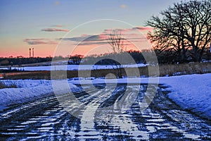 Tire Track Puddles with Sunset Pinks in Sky