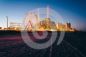 Tire tracks on the beach, rides and hotels at night, in Daytona