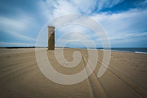 Tire tracks on the beach and a World War II Observation Tower at