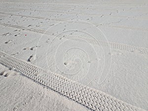 Tire tracks and foot prints on combed beach