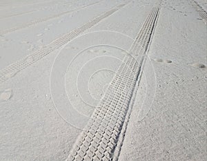 Tire tracks and foot prints on combed beach