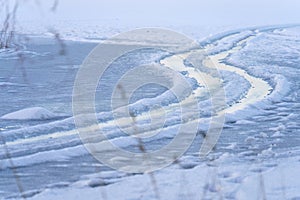 Tire tracks on a frozen lake photo