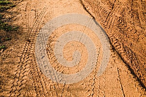 Tire tracks left after a jeep safari on a muddy road. A brown texture with a dirty sandy surface from the Udawalawe National Park