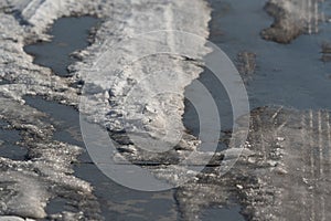 Tire tracks on melting snow. Warming in winter, changing road conditions