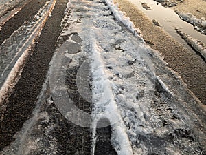 Tire tracks on a snow covered asphalt road