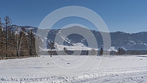 Tire tracks are visible on the trampled road in the snow.