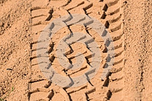 Tire tread footprints of a dump truck on the sand. Construction site. Pattern. Brown abstract background. Car wheel